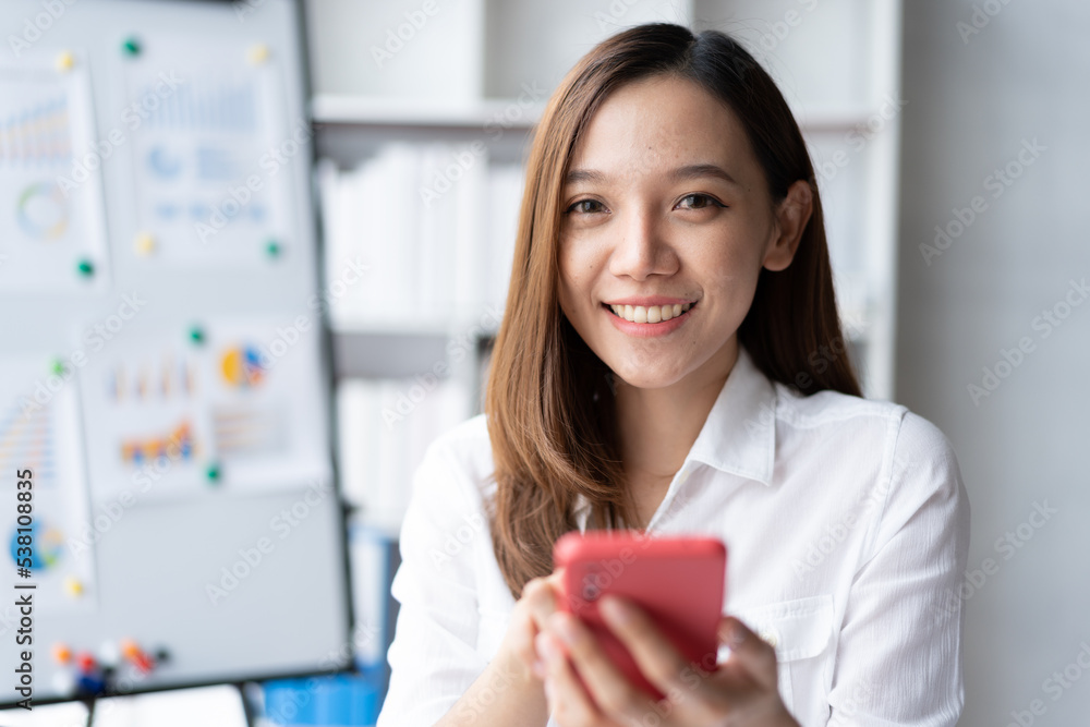 Asian businesswoman in formal suit in office happy and cheerful during using smartphone and working. Asian businesswoman in formal suit in office happy and cheerful during using smartphone and working.