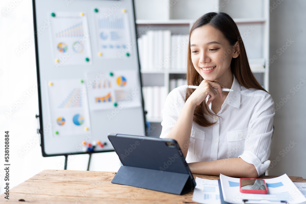 Beautiful Asian business woman working at the office With tablet.