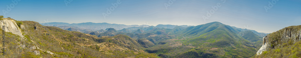 Panoramic view of mountains in summer. Panoramic landscape of green mountain ranges in daylight. Travel and ecotourism concept.