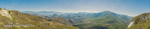 Panoramic view of mountains in summer. Panoramic landscape of green mountain ranges in daylight. Travel and ecotourism concept.