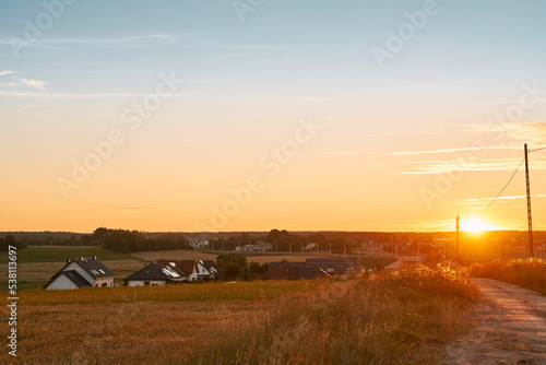 Gorgeous summer sunset landscape. Trees and fields in the rural area. Outdoors adventures in the countryside during summertime vacations.
