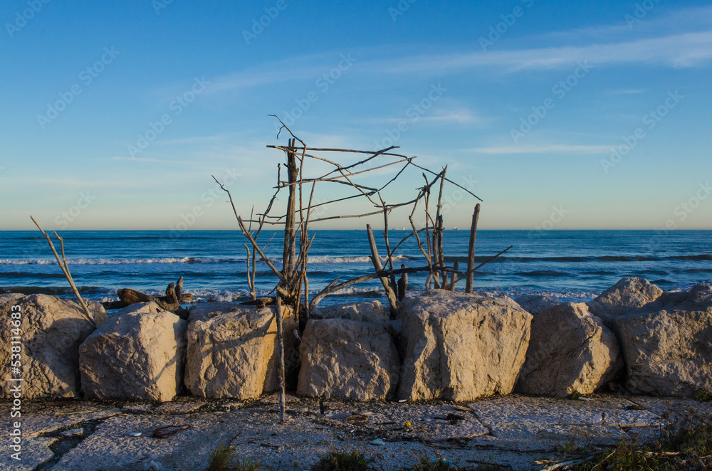 Un capanno costruito con i tronchi di un albero alla spiaggia dei Murazzi al Lido di Venezia