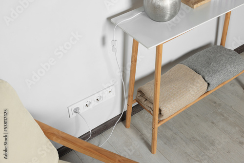 Electric power outlet sockets and plug on white wall indoors photo