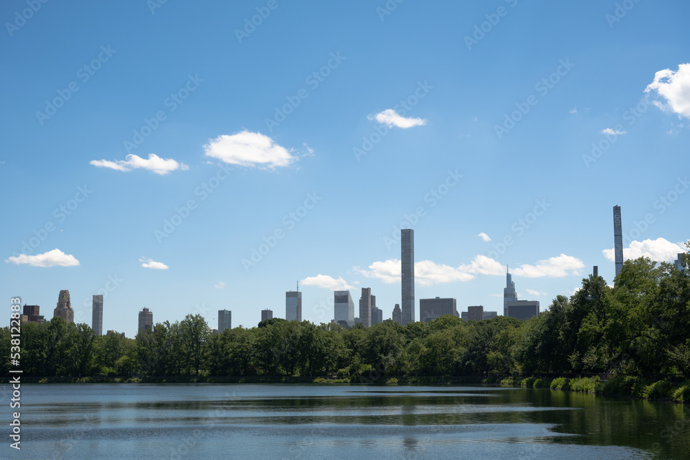 Manhattan skyscrapers seen across the Central Park Reservoir on a sunny summer day