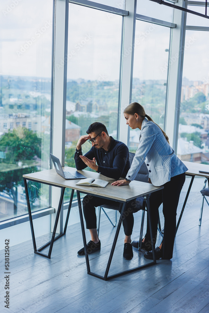 Multiethnic executive team discussing financial report while sitting at table in office. Diverse business people, businessmen planning to work together in a meeting room using a laptop computer.