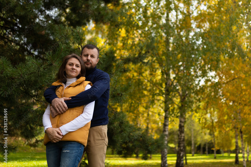 happy adult family traditional couple in autumn forest stands embracing happy adult family traditional couple in autumn forest stands embracing