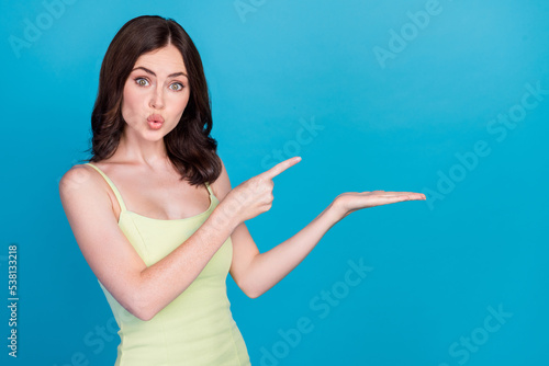 Portrait of impressed person pouted lips indicate finger arm palm hold empty space isolated on blue color background