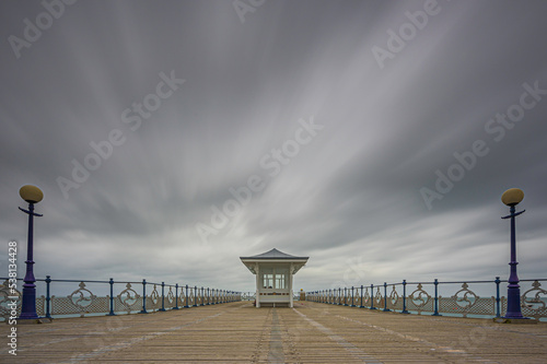 The boardwalk on Swanage Pier, Dorset. The clouds are streaming above the structure. Room for copy photo