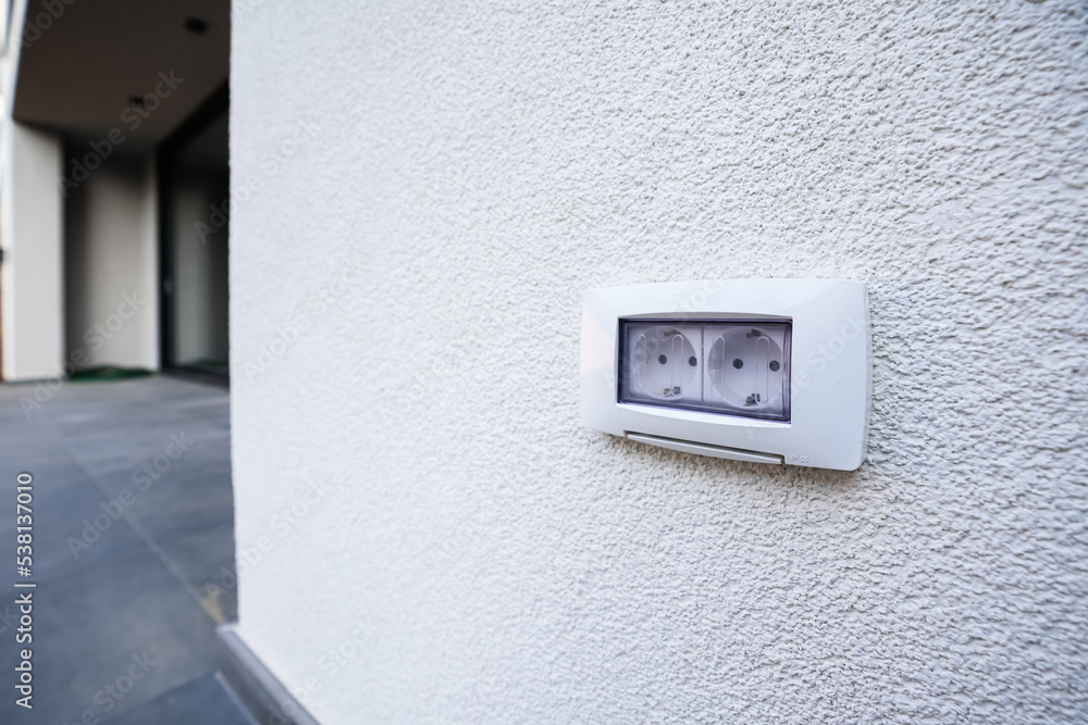 Detail view of an insulated water outlet located on the exterior wall of a house in the yard. House electronics tools and accessories. Detail view of an insulated water outlet located on the exterior wall of a house in the yard. House electronics tools and accessories.
