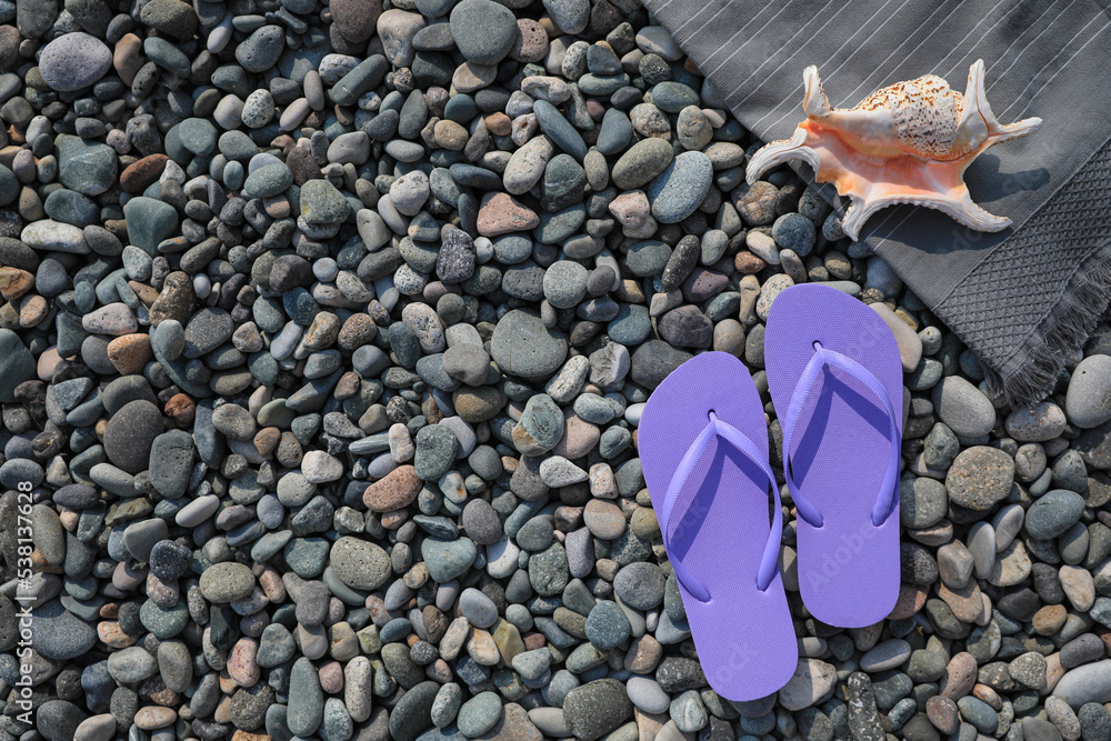 Stylish lilac flip flops and sea shell on stones outdoors, flat lay. Space for text Stylish lilac flip flops and sea shell on stones outdoors, flat lay. Space for text