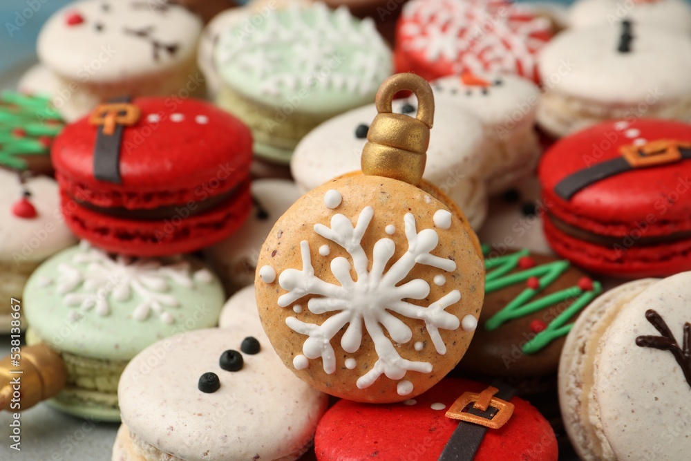 Beautifully decorated Christmas macarons on plate, closeup