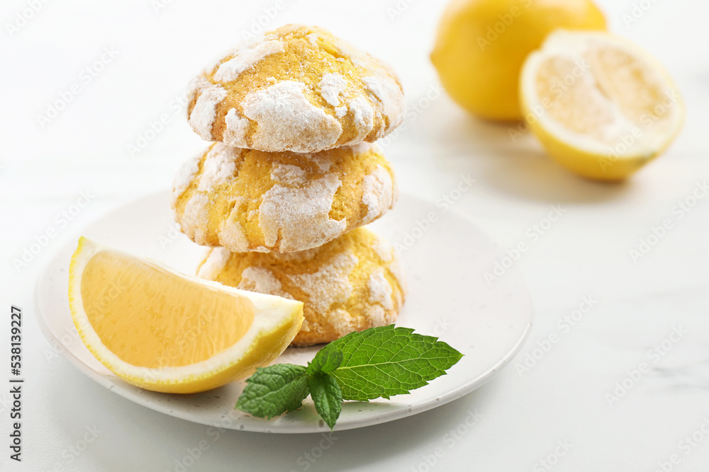Tasty homemade lemon cookies with fresh fruit and mint on white marble table Tasty homemade lemon cookies with fresh fruit and mint on white marble table