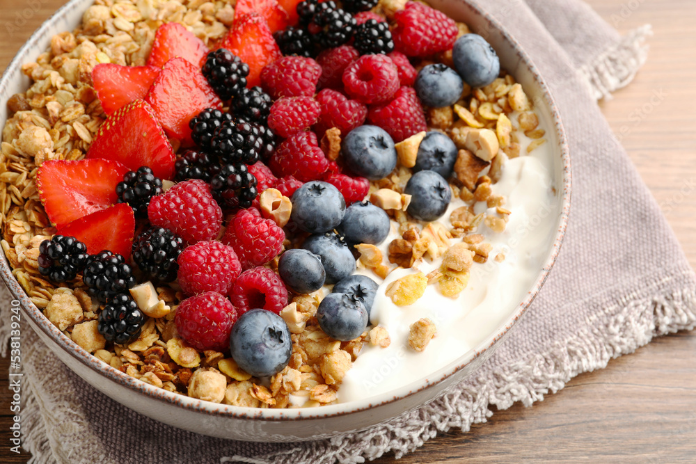 Healthy muesli served with berries on wooden table, closeup Healthy muesli served with berries on wooden table, closeup