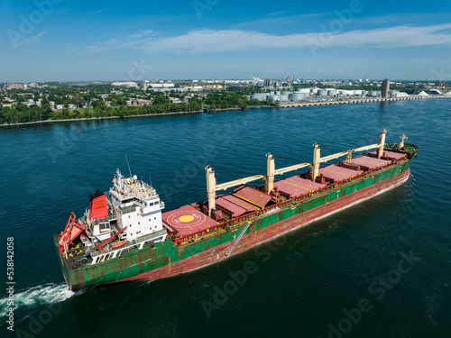 Aerial view of a fully loaded cargo ship leaving the Montreal Port and going downriver on the St.Lawrence River. photo