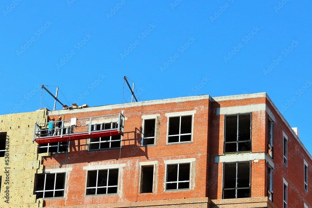 Work on additional insulation of the facade of a house under construction Work on additional insulation of the facade of a house under construction