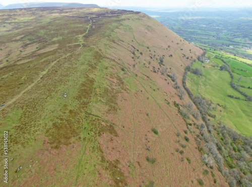 Paraglider flying above the ridge at Pandy, Wales	 photo