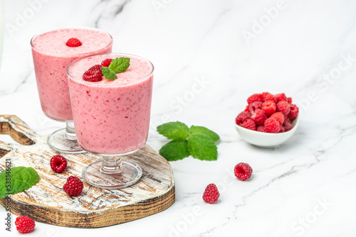 raspberries smoothie milkshake or yogurt in glass jar with berries. Yogurt cocktail on a white background. place for text, top view photo