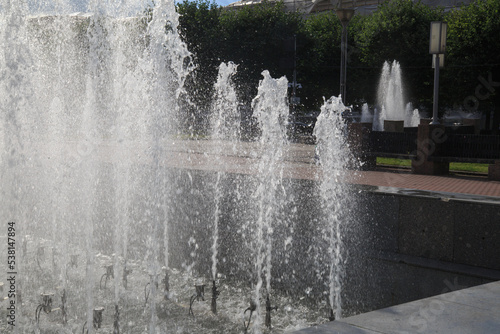 Water streams from a fountain against a cloudy sky.