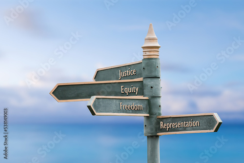 Vászonkép justice equity freedom representation  four word quote written on fancy steel signpost outdoors by the sea