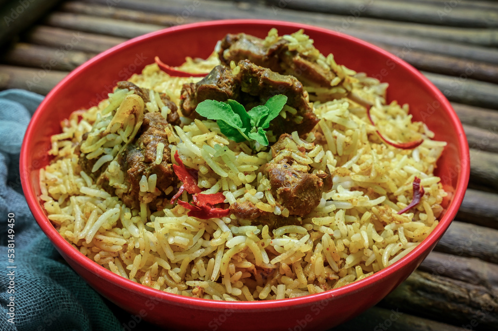 Delicious mutton biryani top view.Biryani rice dish Beautiful Indian rice dish.Delicious spicy chicken biryani in bowl over moody background, it’s a popular Indian and Pakistani food.