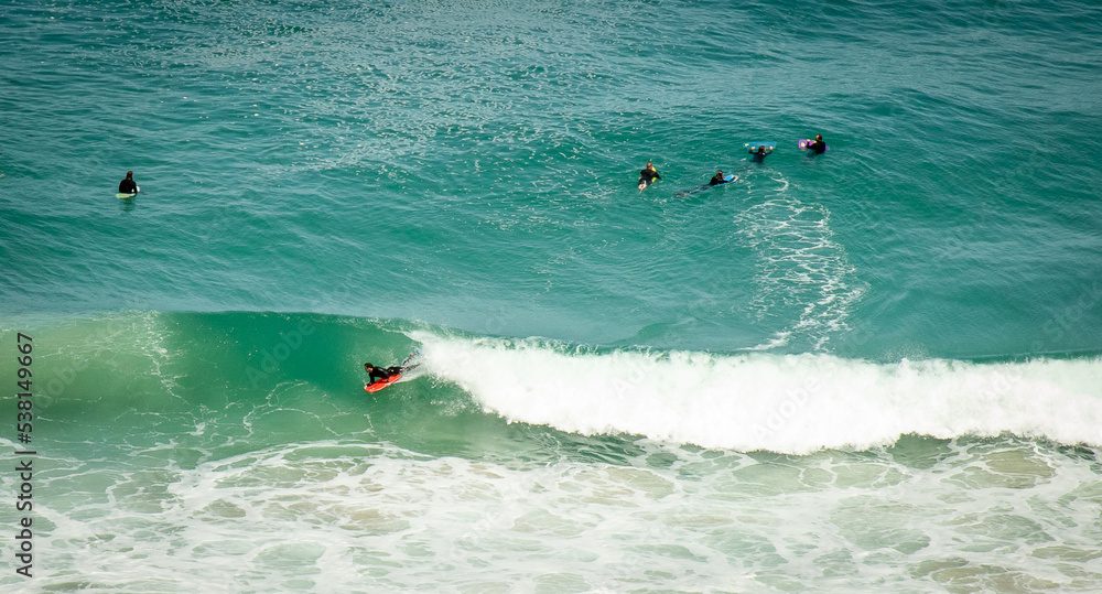 Long shot of bodyboarder riding a big wave