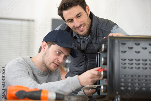 student and teacher repair a computer