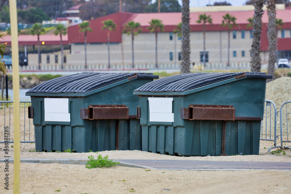Two large commercial dumpsters for trash collection. Two large commercial dumpsters for trash collection.