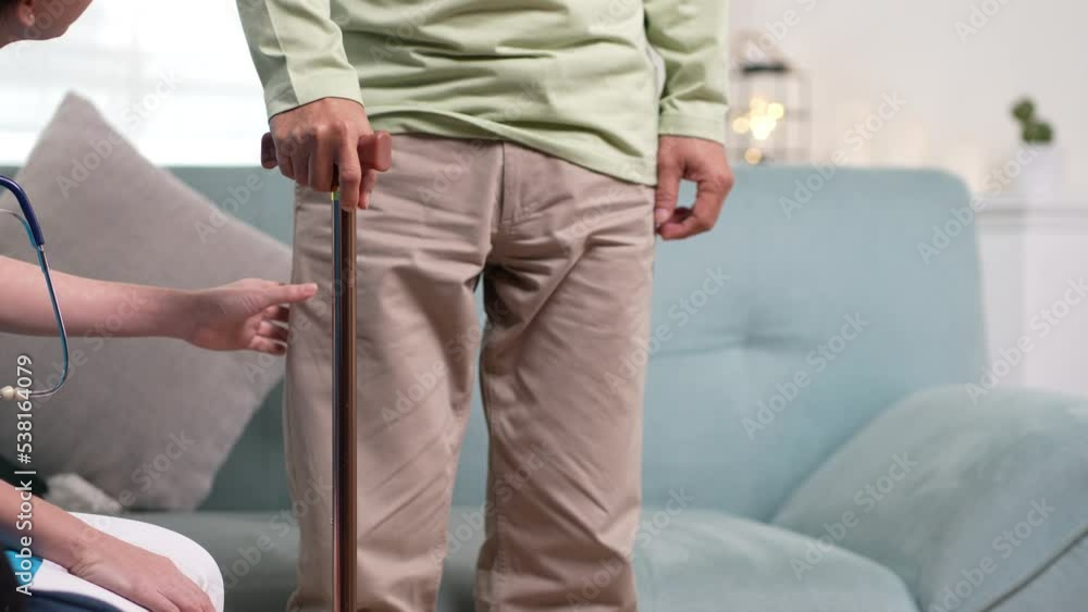 Asian senior elderly man patient doing physical therapy with caregiver. woman nurse helping get up from wheelchair for practice walking with walker at home, practice walk slowly at nursing home care. Asian senior elderly man patient doing physical therapy with caregiver. woman nurse helping get up from wheelchair for practice walking with walker at home, practice walk slowly at nursing home care.