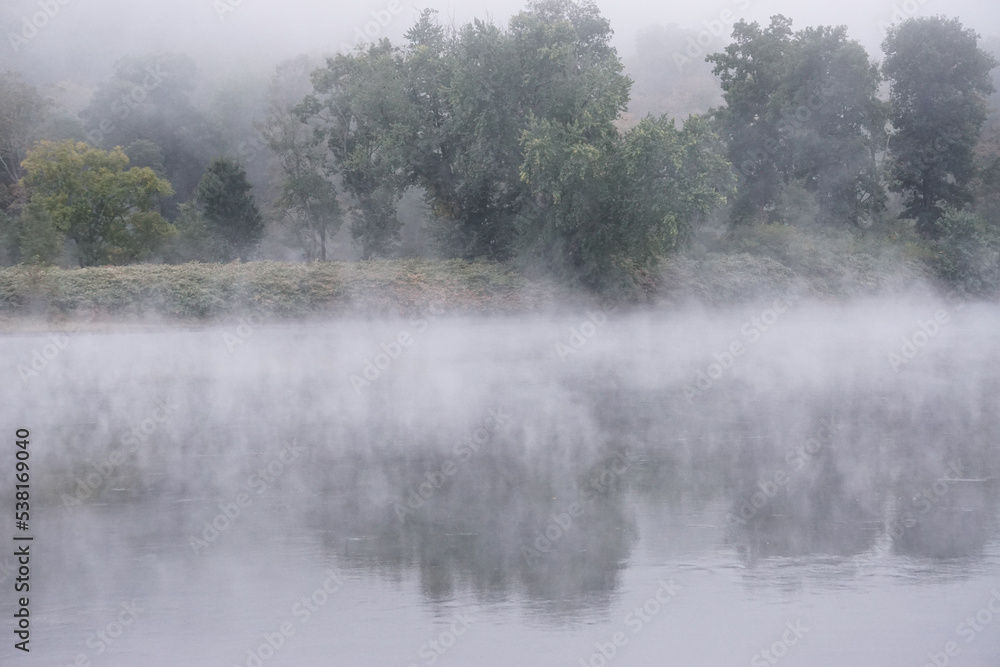 Fototapeta premium Shawnee on Delaware, Pennsylvania, USA: Early morning mist rising from waters of the Delaware River, in the Delaware Water Gap.