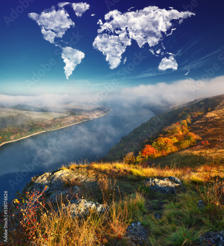 clouds in the form of a world map over the river canyon. conceptual landscape. autumn morning