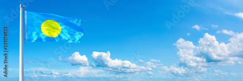 Fototapeta Naklejka Na Ścianę i Meble -  Palau flag waving on a blue sky in beautiful clouds - Horizontal banner
