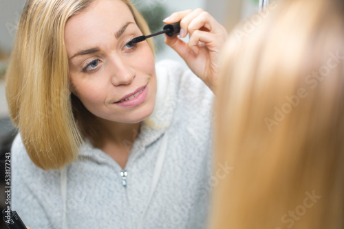 woman applying make up in front of a mirror