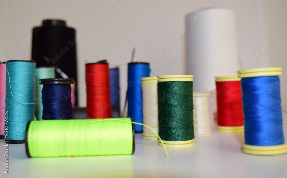 spools of thread and needle, colorful background spools of thread and needle, colorful background