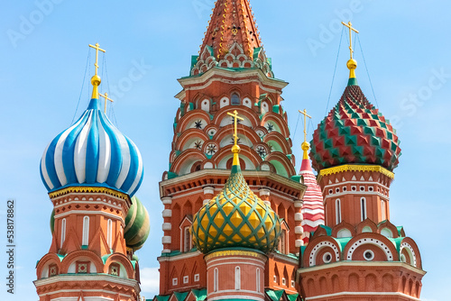 Colored domes of St. Basil's Cathedral against the blue sky. Close-up