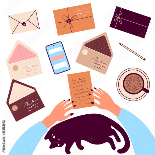 Top view on woman hands reading letter with cat and envelops