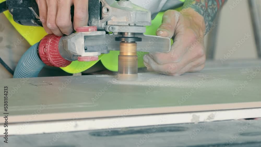 Drilling holes in ceramic tiles. A worker drills holes for