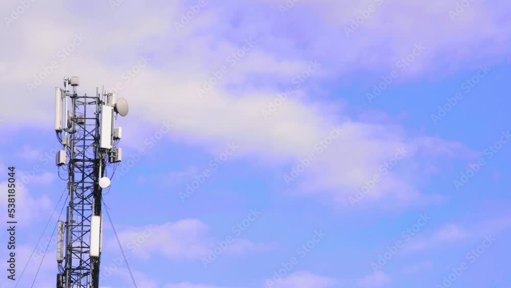Cell site antenna on a blue sky and white clouds background. Cellular tower base station with electronic communications equipment. Cell tower with mobile Telecommunications equipment. Place for text Cell site antenna on a blue sky and white clouds background. Cellular tower base station with electronic communications equipment. Cell tower with mobile Telecommunications equipment. Place for text