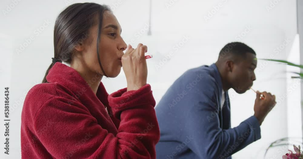 Video of happy diverse couple brushing teeth at sink in bathroom at home Video of happy diverse couple brushing teeth at sink in bathroom at home
