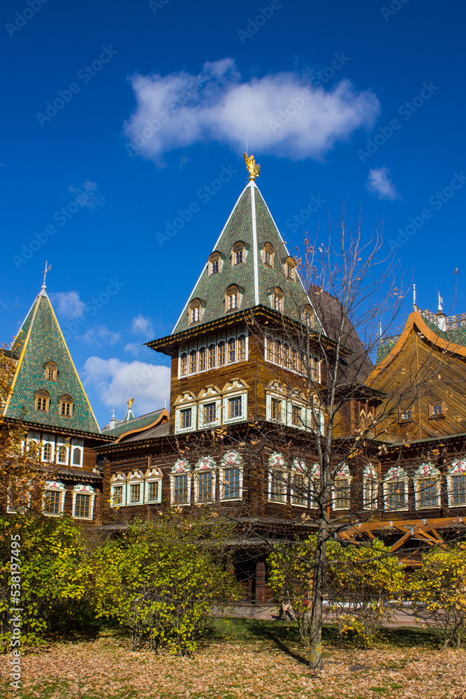 MOSCOW, RUSSIA - OCTOBER, 15, 2022: the historic wooden palace of Tsar Alexei Mikhailovich Romanov in Kolomenskoye Park among autumn trees on a bright sunny October day and blue sky
