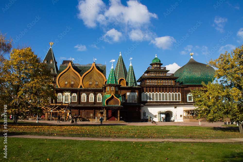 MOSCOW, RUSSIA - OCTOBER, 15, 2022: the historic wooden palace of Tsar Alexei Mikhailovich Romanov in Kolomenskoye Park among autumn trees on a bright sunny October day and blue sky
