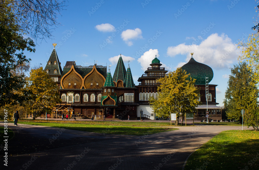 MOSCOW, RUSSIA - OCTOBER, 15, 2022: the historic wooden palace of Tsar Alexei Mikhailovich Romanov in Kolomenskoye Park among autumn trees on a bright sunny October day and copy space