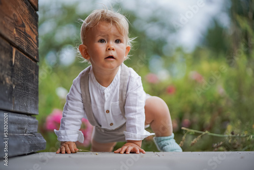 Photography happy one year old baby boy sitting or crawling in chic festive summer clothes o