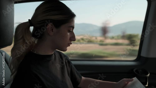 modern young woman traveling reading a book in vip vehicle