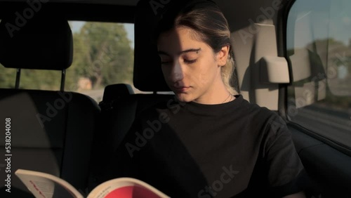 modern young woman traveling reading a book in vip vehicle