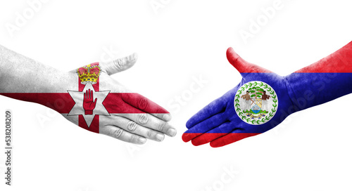 Handshake between Belize and Northern Ireland flags painted on hands, isolated transparent image. photo