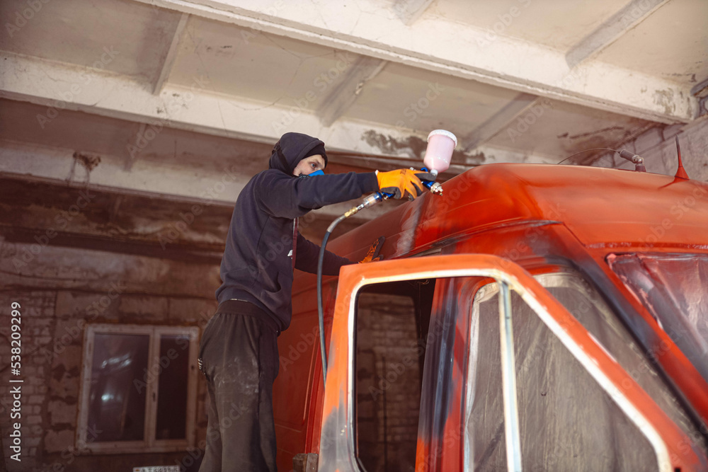 Spray painting a van car red. Restoration and body repair of cars