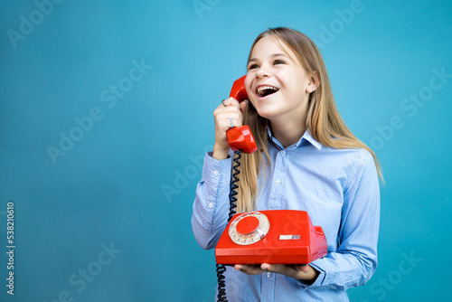 young woman with a red retro phone in her hands