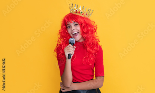 girl smile in crown with microphone on yellow background