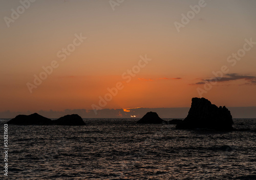 Calm sea with sunset sky and sun through the clouds over. Tranquil seascape and horizon over the water