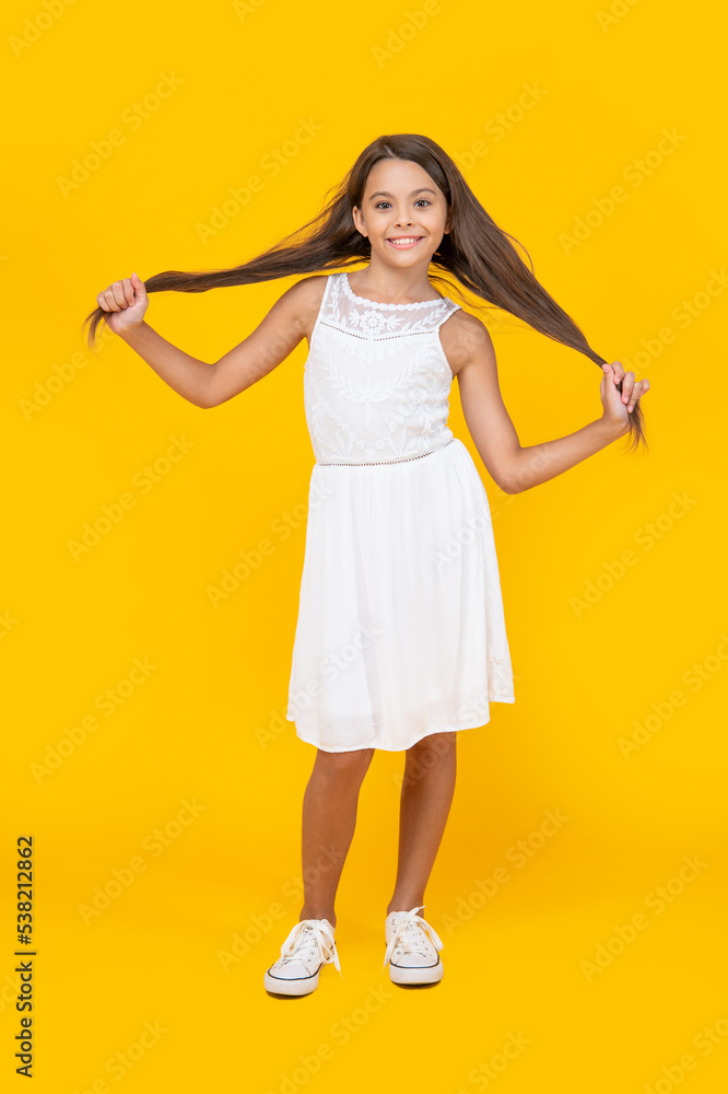 cute teen girl with long hair standing on yellow background cute teen girl with long hair standing on yellow background